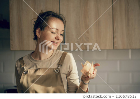 A young woman hold cupcake in a craft box. concept of food delivery. birthday package. small business. The bakery chef bakes pastries and cakes in the kitchen A young woman hold cupcake in a craft box. concept of food delivery. birthday package. small business. The bakery chef bakes pastries and cakes in the kitchen 110678512
