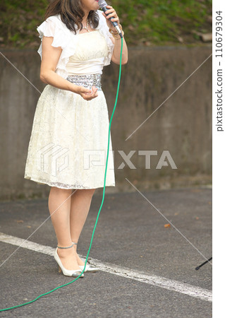 Woman singing at an outdoor event 110679304