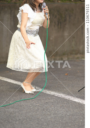 Woman singing at an outdoor event 110679311