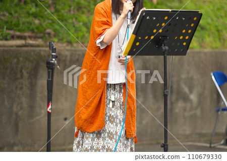Woman singing at an outdoor event 110679330
