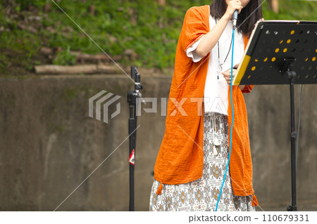 Woman singing at an outdoor event 110679331