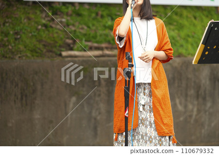 Woman singing at an outdoor event 110679332