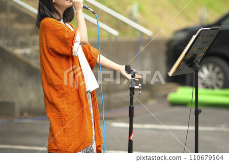 Woman singing at an outdoor event 110679504