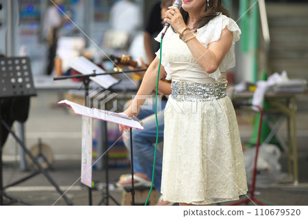 Woman singing at an outdoor event 110679520
