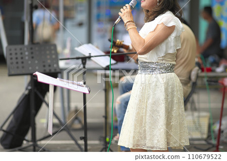 Woman singing at an outdoor event 110679522