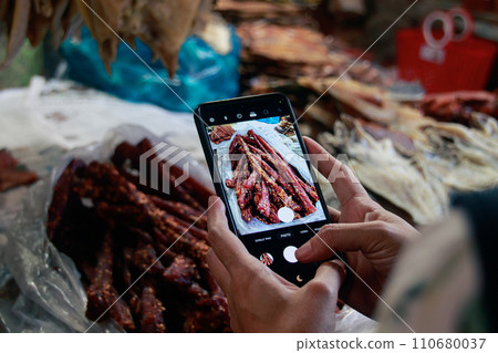 Capturing an image of traditional cambodian beef jerky called sach ko ngeat at the local Samaki Market with a smartphone. Kampot, Cambodia Capturing an image of traditional cambodian beef jerky called sach ko ngeat at the local Samaki Market with a smartphone. Kampot, Cambodia 110680037