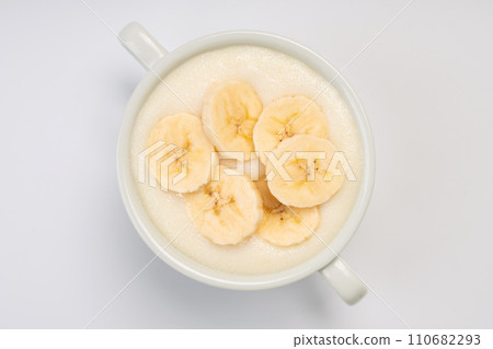 Breakfast. Semolina porridge with banana on a white plate and a white background Breakfast. Semolina porridge with banana on a white plate and a white background 110682293