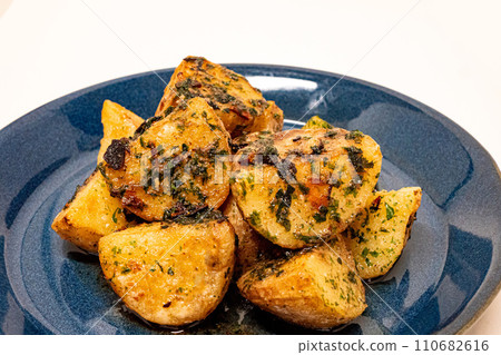 Seaweed salted butter potatoes served on a blue plate Seaweed salted butter potatoes served on a blue plate 110682616