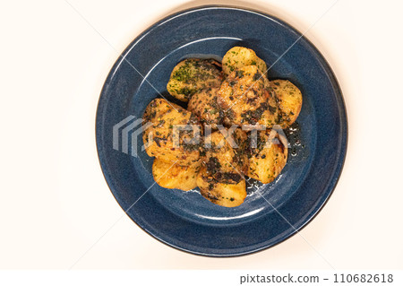 Seaweed salted butter potatoes served on a blue plate Seaweed salted butter potatoes served on a blue plate 110682618