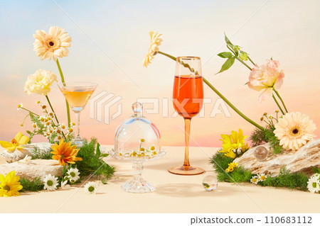 Daisies are displayed on a glass pedestal, above is a glass dome cover. Fresh flowers and green grass are decorated with stone slabs. A cocktail and a glass of wine stand out against the sunset sky. Daisies are displayed on a glass pedestal, above is a glass dome cover. Fresh flowers and green grass are decorated with stone slabs. A cocktail and a glass of wine stand out against the sunset sky. 110683112