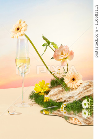 A glass of white wine, a glass marble, a mirror, fresh flowers and green grass are decorated on a stone slab. Sunset scene with beige background. Copy space. A glass of white wine, a glass marble, a mirror, fresh flowers and green grass are decorated on a stone slab. Sunset scene with beige background. Copy space. 110683115