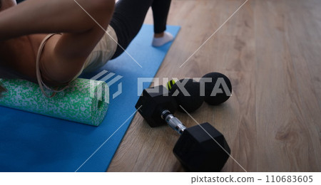 Woman does exercises lying on roller and balancing 110683605