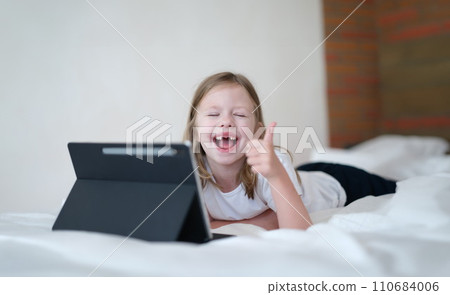 Happy baby girl holding thumbs up with tablet Happy baby girl holding thumbs up with tablet 110684006