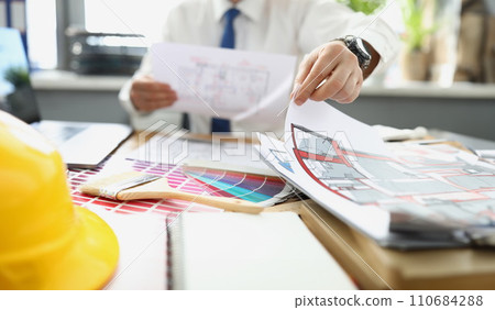 Successful designer work on new project, palette on desk, house plan 110684288