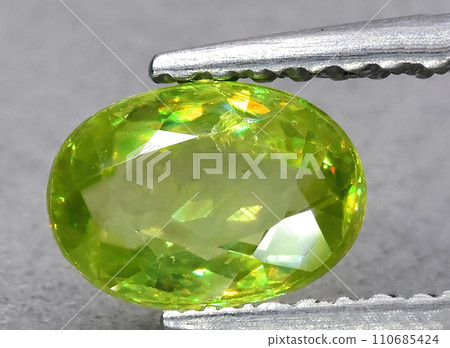natural green sphene gem on the background 110685424