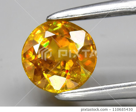 natural yellow sphene gem on the background 110685430
