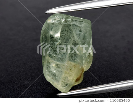 natural green sapphire rough gem on the background natural green sapphire rough gem on the background 110685490