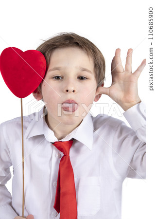 Child with Valentine. A boy with a red heart grimaces. Child with Valentine. A boy with a red heart grimaces. 110685900