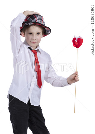 Child with Valentine. The boy in the hat holds a red heart. Beautiful fashionable child. Child with Valentine. The boy in the hat holds a red heart. Beautiful fashionable child. 110685903