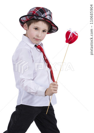 Child with Valentine. The boy in the hat holds a red heart. Beautiful fashionable child. Child with Valentine. The boy in the hat holds a red heart. Beautiful fashionable child. 110685904