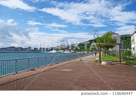Kanmon Bridge with people walking along the Mekari Observation Promenade in Moji Ward, Kitakyushu City 110686447