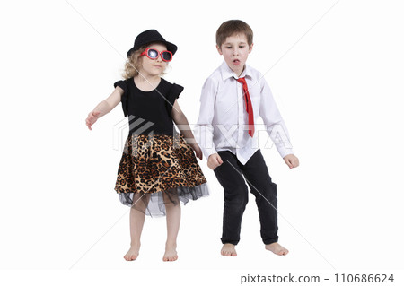 Funny kids dancing on a white background. Little girl in a hat and a boy in a tie are dancing. Ballroom dancing. Dance couple Funny kids dancing on a white background. Little girl in a hat and a boy in a tie are dancing. Ballroom dancing. Dance couple 110686624