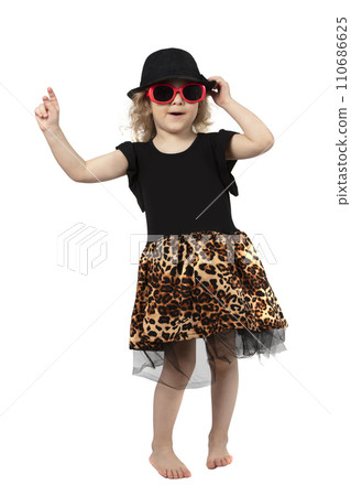 Full length funny little girl in a black hat and sunglasses on a white background. Beautiful fashionable child. Four-year-old baby blonde. Full length funny little girl in a black hat and sunglasses on a white background. Beautiful fashionable child. Four-year-old baby blonde. 110686625