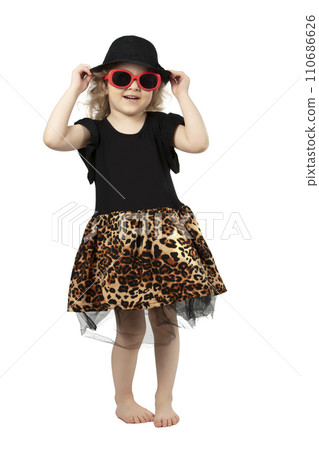 Full length funny little girl in a black hat and sunglasses on a white background. Beautiful fashionable child. Four-year-old baby blonde. Full length funny little girl in a black hat and sunglasses on a white background. Beautiful fashionable child. Four-year-old baby blonde. 110686626