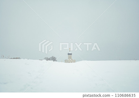 a church in winter in the middle of a snow-covered field 110686635