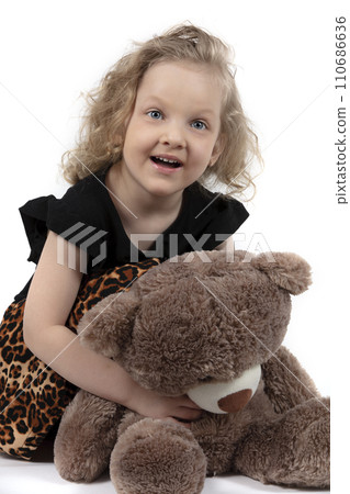 Beautiful child. Little girl with a teddy bear. Happy five year old girl. Blue-eyed curly blonde. Preschooler with a soft toy. Beautiful child. Little girl with a teddy bear. Happy five year old girl. Blue-eyed curly blonde. Preschooler with a soft toy. 110686636