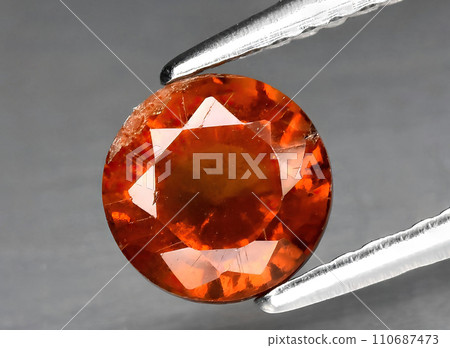 natural orange hessonite gem on the background natural orange hessonite gem on the background 110687473