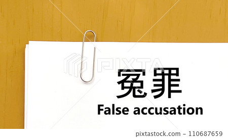 Paper with words of false accusation attached with a paper clip_Overhead view 110687659