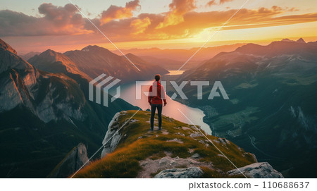 An adventurous mountaineer reaches the summit at sunrise. An image of overcoming a difficult situation through teamwork. AI image 110688637