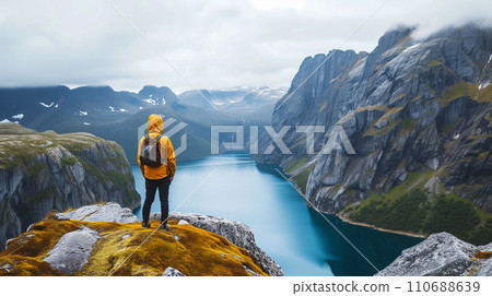 一位富有冒險精神的登山者在日出時到達山頂。透過團隊合作克服困難的形象。人工智慧影像 110688639