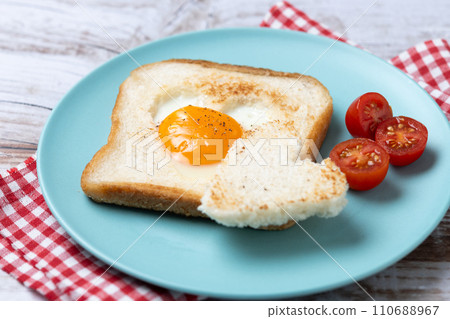 Valentine's Day breakfast with egg with tomatoes, heart shaped and toast bread on wooden table. 110688967