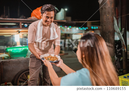 male seller serving fried rice to customer male seller serving fried rice to customer 110689155