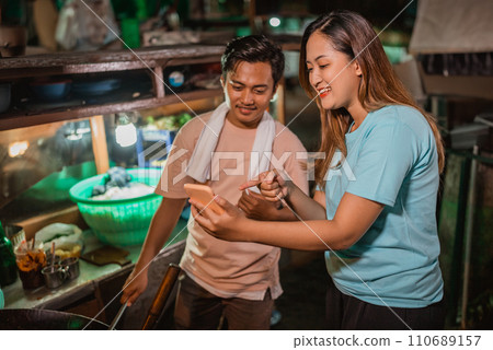 female customer holding phone pointing gesture 110689157