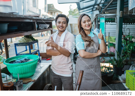 indonesian couple standing behind traditional food cart indonesian couple standing behind traditional food cart 110689172