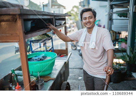 indonesian man standing behind his traditional food cart indonesian man standing behind his traditional food cart 110689344