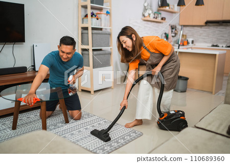 joyful couple doing household chores together joyful couple doing household chores together 110689360