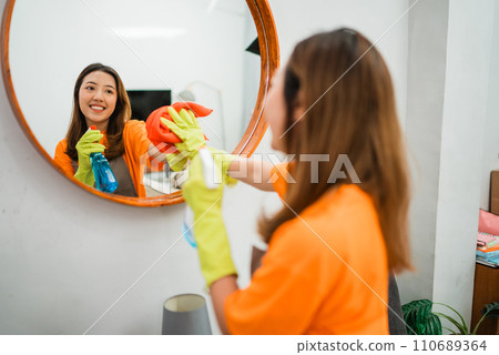 asian woman spraying and wiping mirror asian woman spraying and wiping mirror 110689364