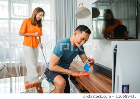 asian couple doing house chores together asian couple doing house chores together 110689433