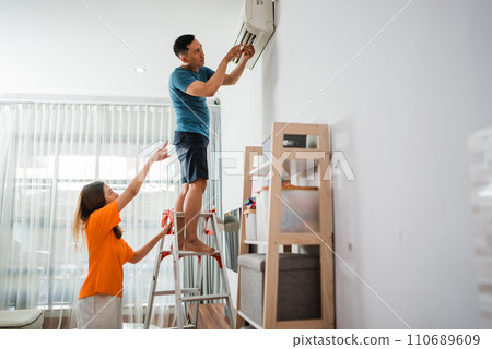 asian man fixs broken air conditioner asian man fixs broken air conditioner 110689609