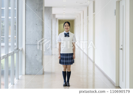 A female high school student standing in the school hallway smiling and looking at the camera.Full body photo cooperation: Ariake College of Education and Arts 110690579