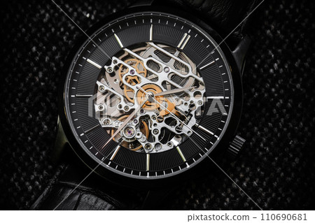 Black clock face with metal details of mechanic skeleton watch 110690681