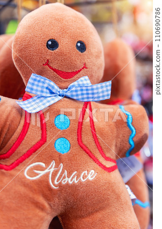 Many traditional Alsace symbol gingerbread man cookie plush toy hanged on Strasbourg city street market sale. France alsatian souvenir travel tourism destination 110690786