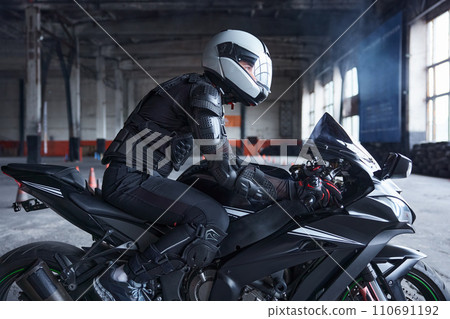 Biker wearing protective helmet and uniform for speed riding at training class 110691192