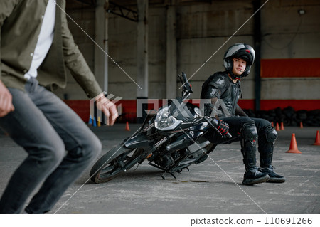 Instructor explaining student motorcyclist his mistake at training class 110691266