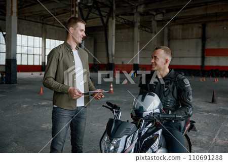 Student learning how to drive motorcycle with one hand 110691288