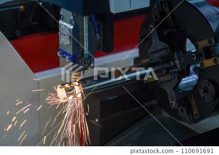 Close up scene the fiber laser cutting machine cut the stainless steel tube and sparkling light. 110691691